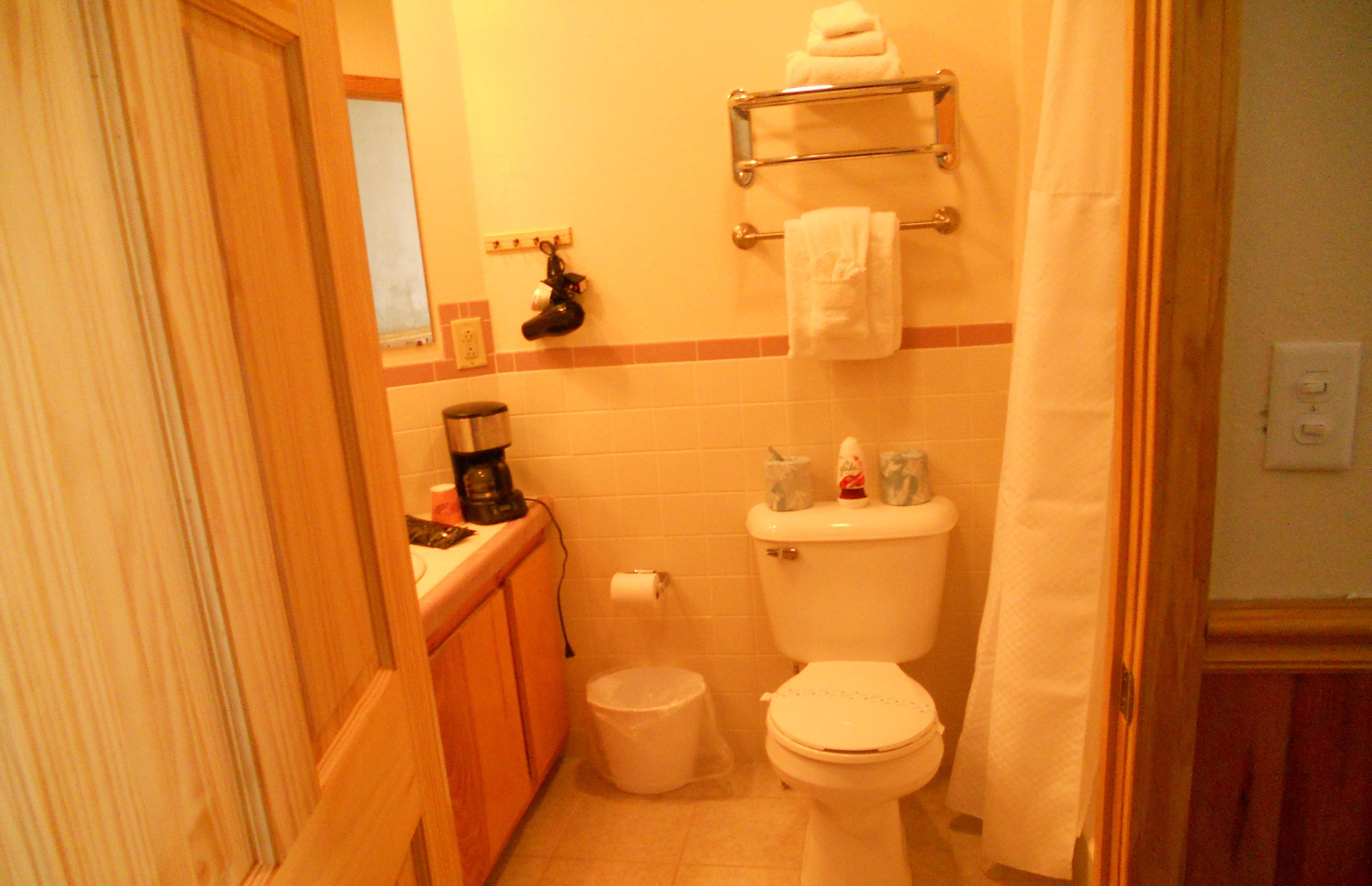 A small bathroom with a toilet, a sink, and a shower curtain.