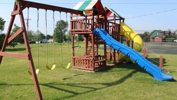 A playground with a swing set and a slide.