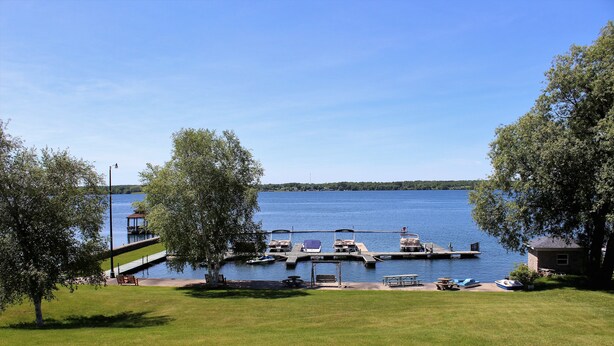 A lakeside view with a dock, boats, and a gazebo. - The Stonefence Resort (Ogdensburg)