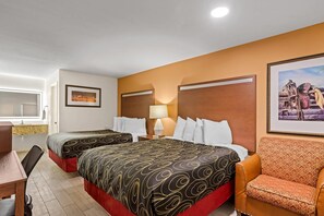 Une chambre d’hôtel avec deux lits, un bureau, une chaise et un tableau au mur.