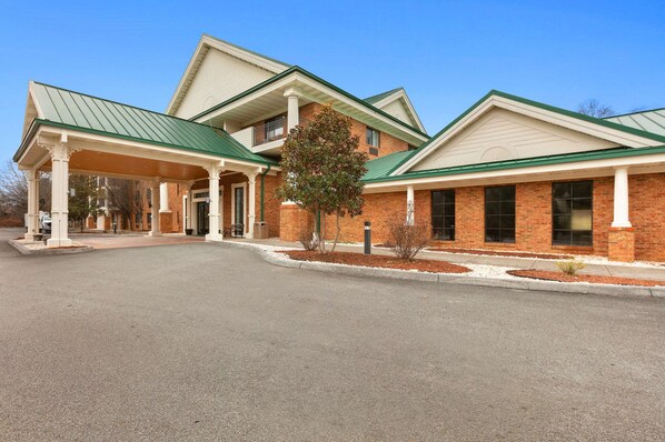 A two-story building with a covered entrance and a brick facade.