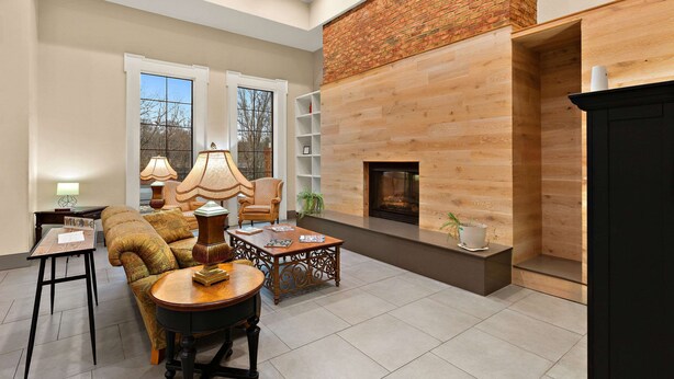 A spacious living room with a fireplace, a sofa, a coffee table, and a bookshelf.
