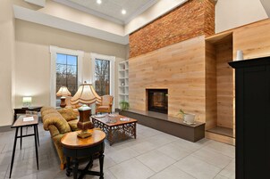 A spacious living room with a fireplace, a sofa, a coffee table, and a bookshelf.