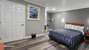Une chambre à coucher avec un lit, une table de chevet et une lampe fixée au mur.