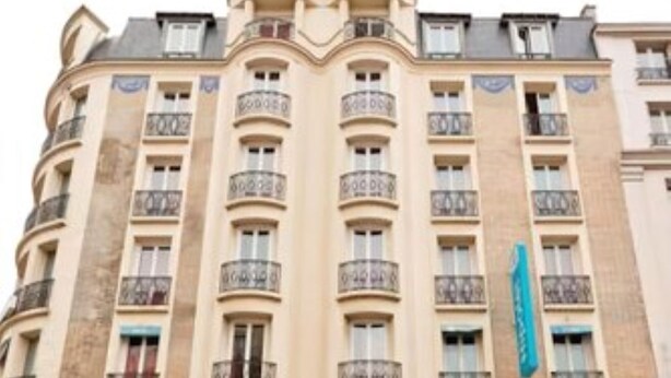 A multi-story hotel with a classic architectural design, featuring balconies and a central entrance. - Hipotel Paris Printania Maraîchers (Paris)