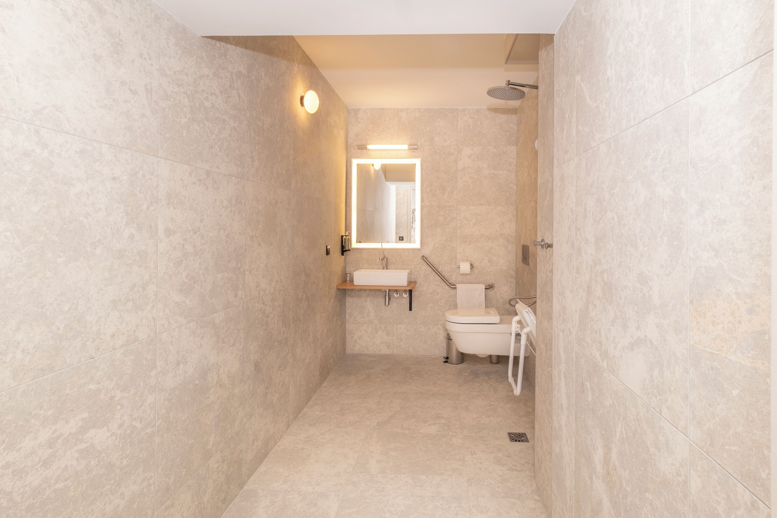 Un baño moderno con cabina de ducha, inodoro y lavamanos.