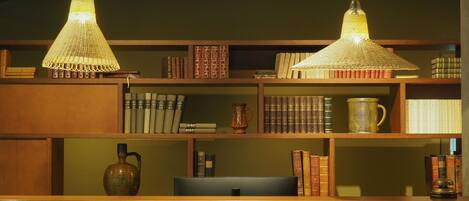 A bookshelf with books and decorative items, two hanging lamps, and a vase.