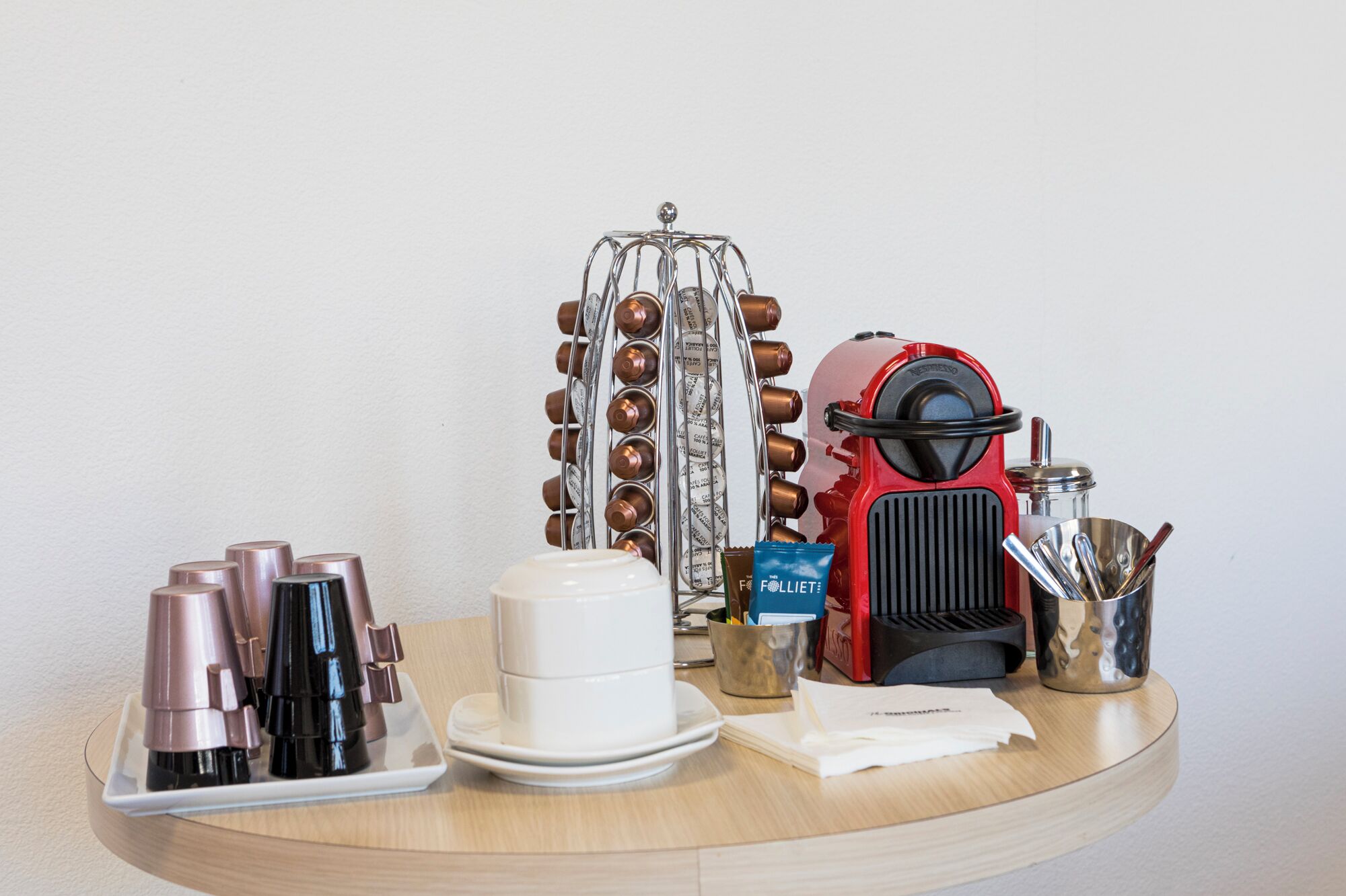 A coffee machine, a coffee press, a cup, a tray, and a container with utensils.