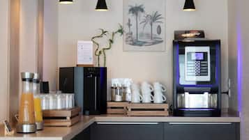 Una moderna area caffè con una macchina da caffè digitale, una bacheca con il menù e una pianta.