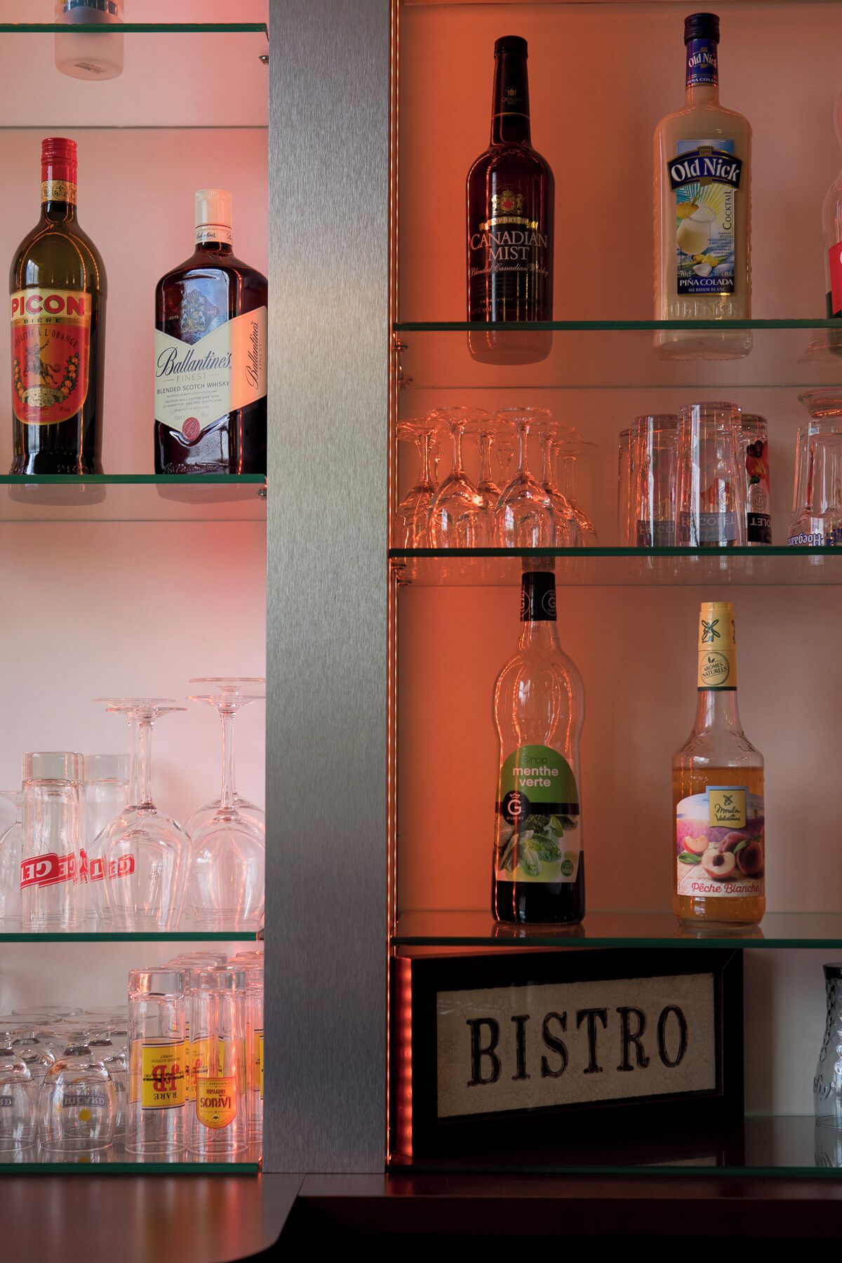 Eine Bar mit Regalen voller Spirituosenflaschen und Gläsern.