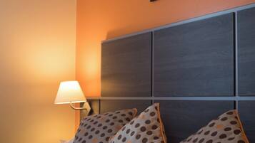 Una habitación de hotel con una cama, un cabecero y un cuadro colgado en la pared.