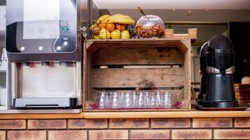 Pared de ladrillo con una máquina de café, una vitrina con frutas y una cafetera.