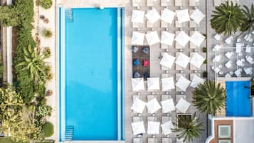 Una piscina cubierta, una piscina al aire libre, sombrillas, tumbonas