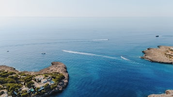 Vista aérea de una zona costera con afloramientos rocosos y un mar azul cristalino.