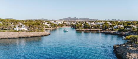 A coastal town with a marina, rocky shoreline, and residential buildings.