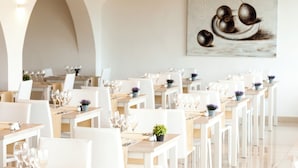 A restaurant with white tables and chairs, arranged in rows. - Grupotel Rocador (Santanyi)