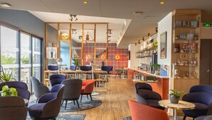 Un interior moderno con zonas de estar, un bar y una estantería con diversos objetos.