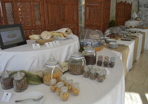 A buffet table with various food items and condiments, surrounded by wooden paneling.