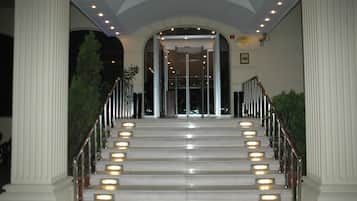 Step into a grand entrance, framed by elegant columns and lit by soft lights.