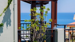 A terrace with a pergola, a planter with a plant, and two white chairs. - Kastro Hotel (Heraklion)