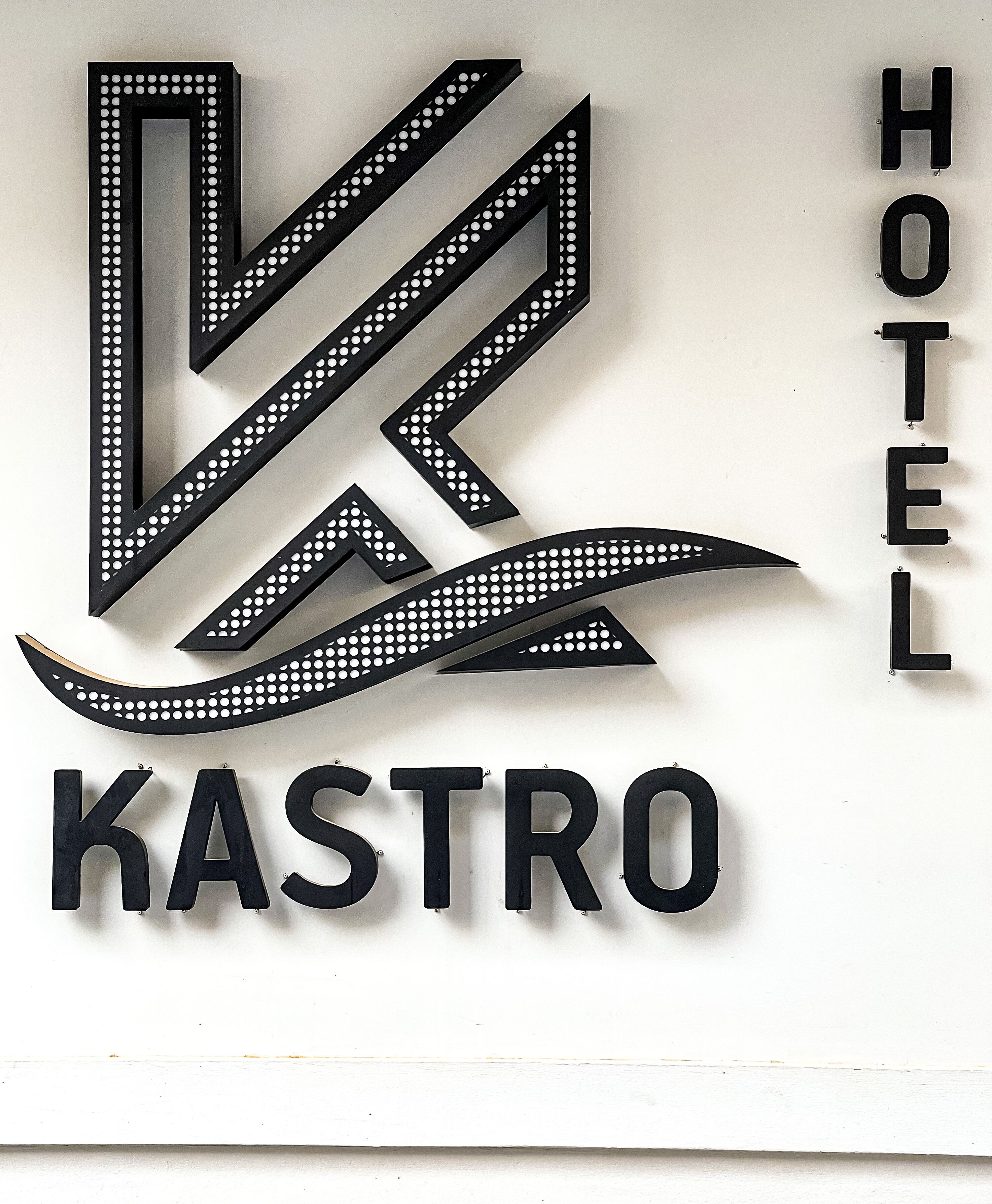 A hotel sign with a stylized logo and the name "KASTRO HOTEL" in bold letters.