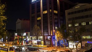 Um hotel com uma placa chamativa, vários andares e um design arquitetônico moderno.