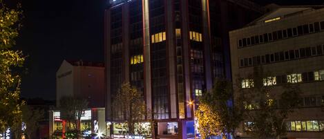 Un hotel con un cartello ben visibile, diversi piani e un design architettonico moderno.