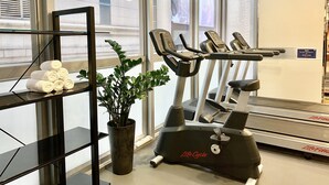A gym with treadmills, a potted plant, and a shelf with towels. - Holiday Inn Express Causeway Bay Hong Kong by IHG (Hong Kong)