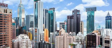 A cityscape with high-rise buildings, including a prominent building with a sign in a foreign language.