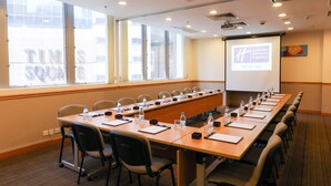 A conference room with a long table, chairs, water bottles, and a projector screen. - Holiday Inn Express Causeway Bay Hong Kong by IHG (Hong Kong)