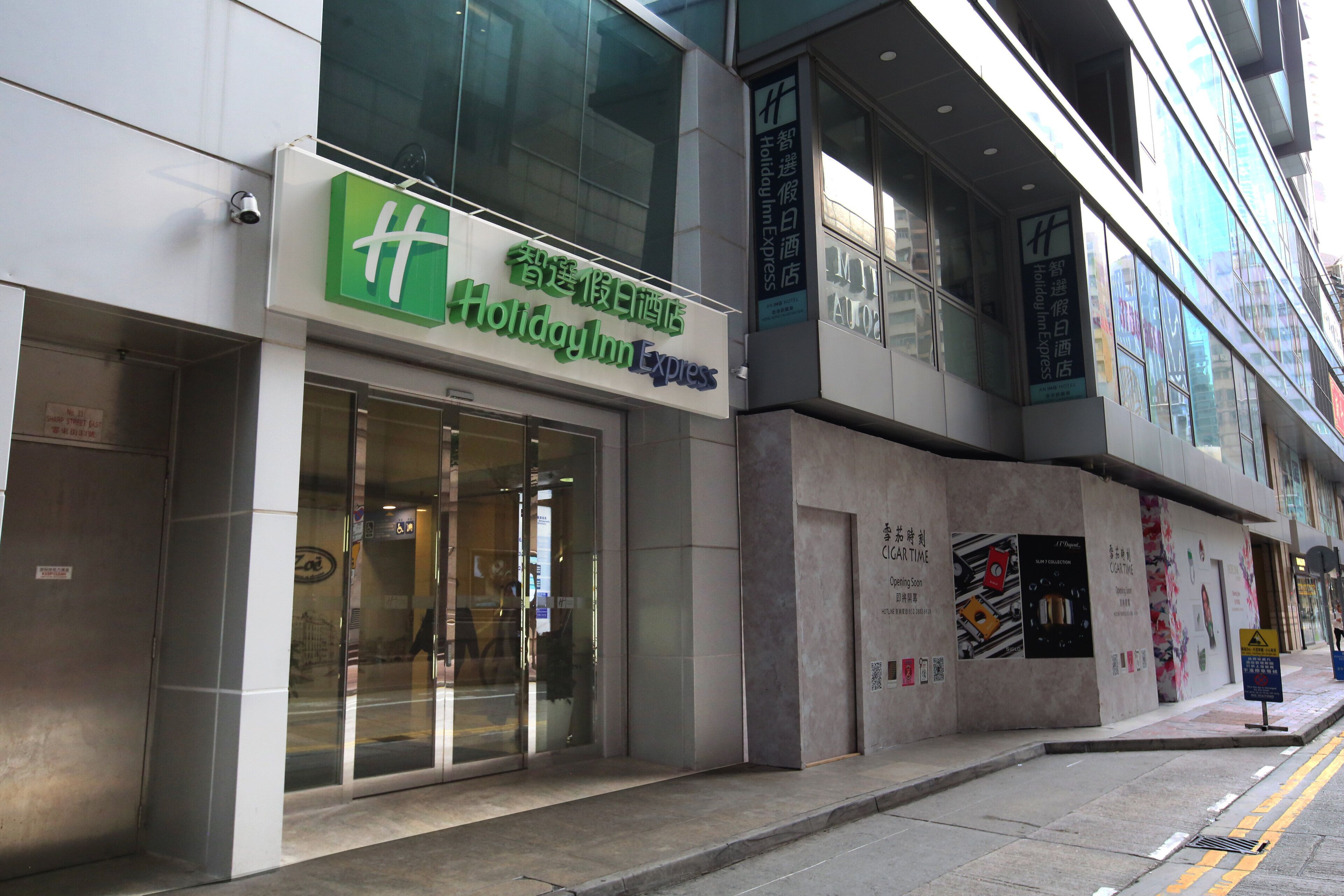 A Holiday Inn Express hotel with a glass facade and signage in multiple languages.