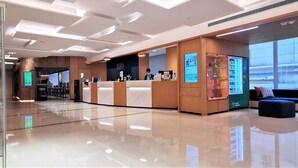 A modern reception area with a glass partition, a reception desk, and a display of awards. - Holiday Inn Express Causeway Bay Hong Kong by IHG (Hong Kong)
