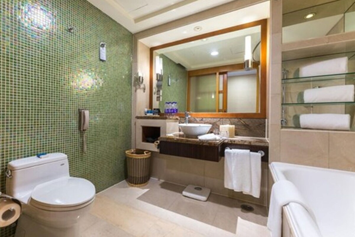 Un baño con inodoro, lavabo, espejo y bañera.