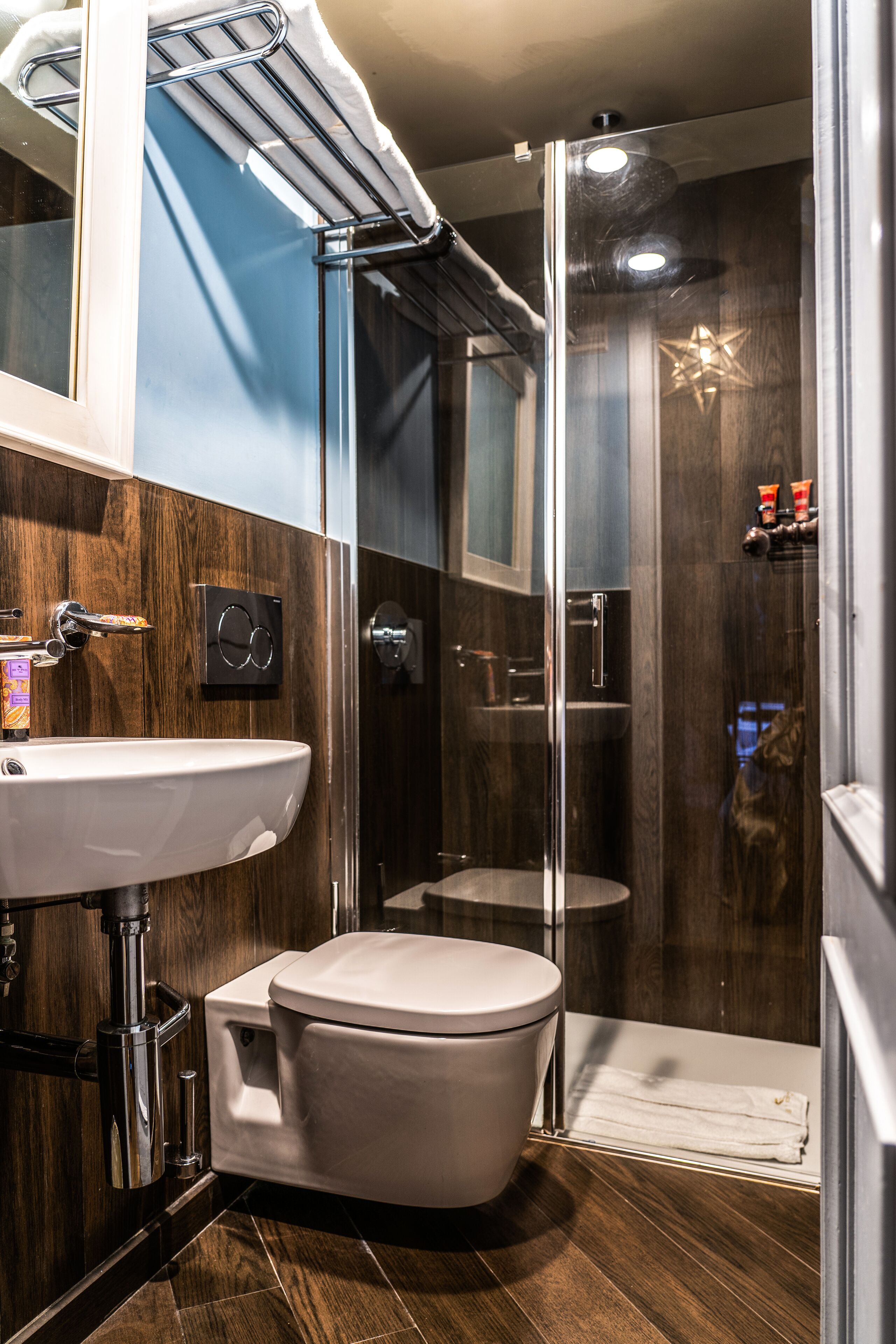 A modern bathroom with a toilet, sink, and glass-enclosed shower.