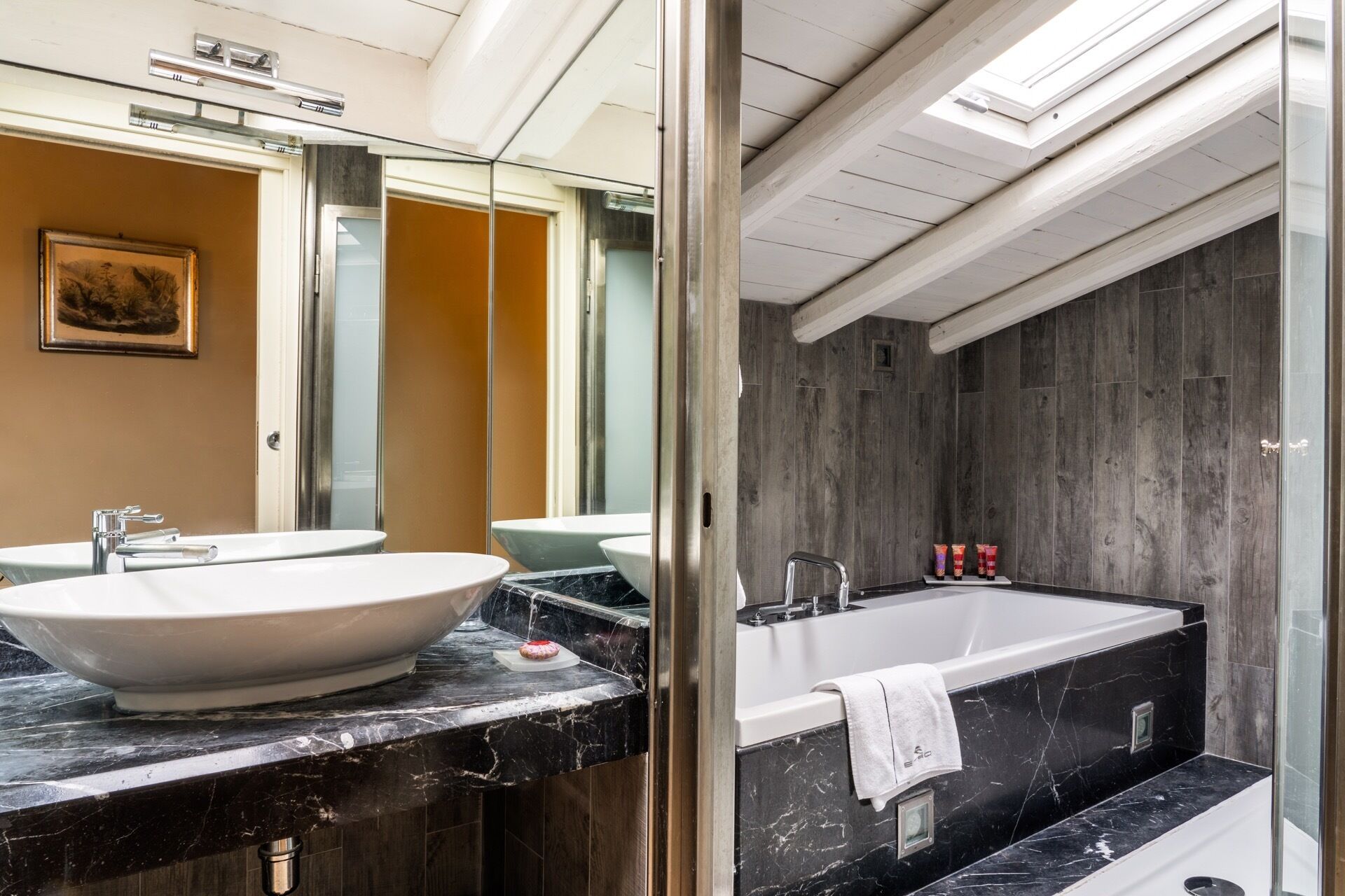 Ein modernes Badezimmer mit einem großen, weißen Waschbecken, einer Badewanne und einem Spiegel.