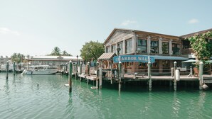 A waterfront property with a dock, a boat, and a building with a sign reading "Harbor Walk". - Fitch Lodge - Key West Historic Inns (Key West)