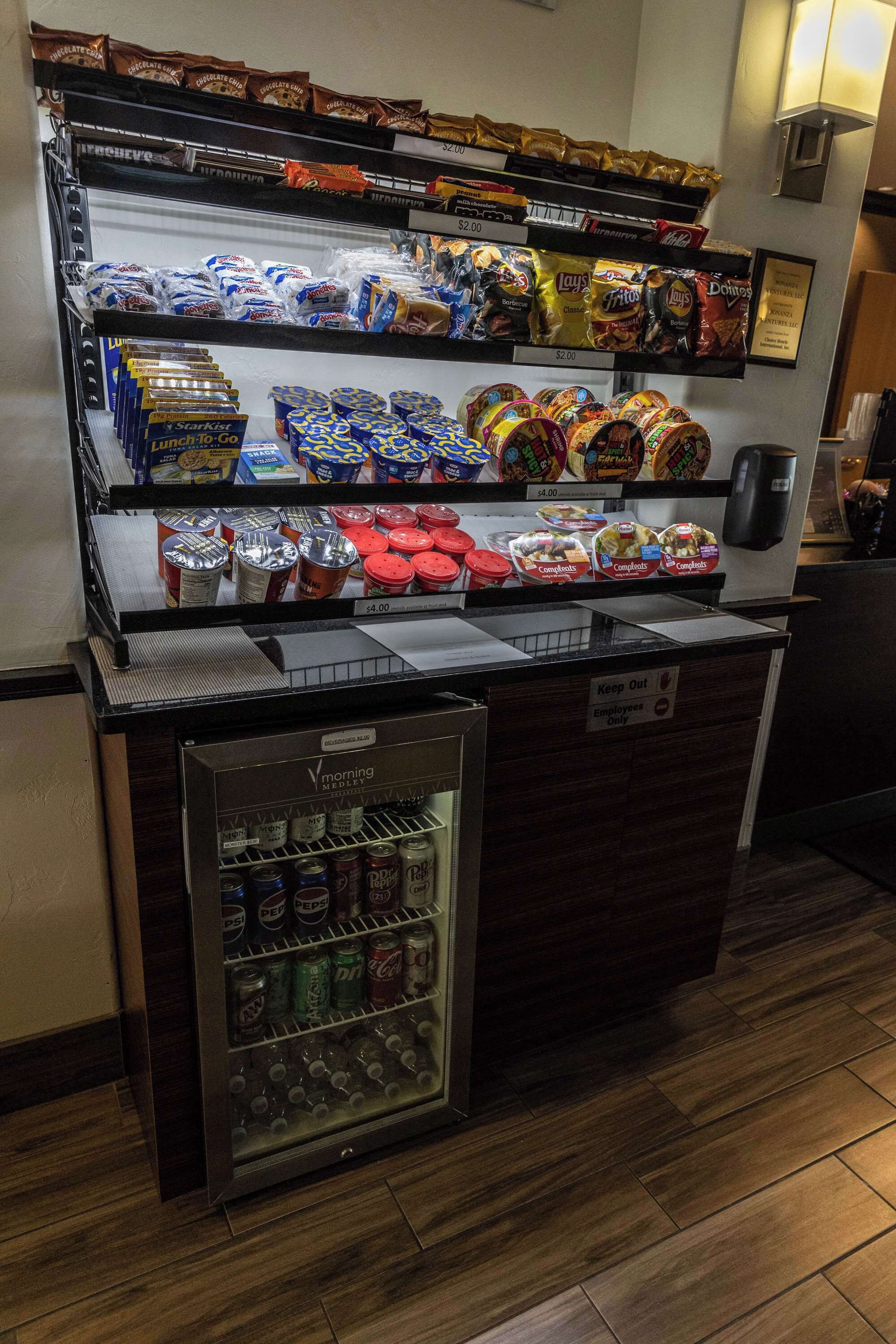 A vending machine with snacks and drinks, including chips, candy, and canned beverages.