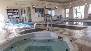 A swimming pool area with lounge chairs, a hot tub, and a changing room with towels. - Sleep Inn & Suites Evansville - Casper (Evansville)