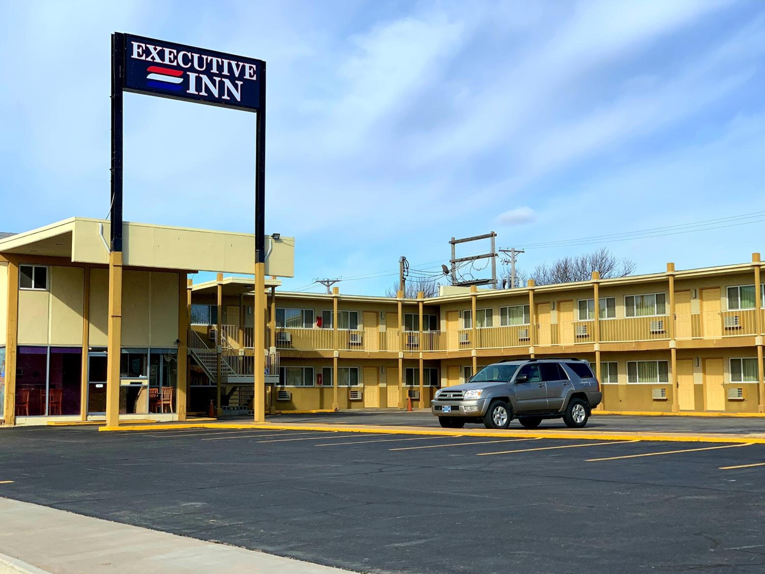 Un motel à deux étages avec une enseigne indiquant « EXECUTIVE INN ».