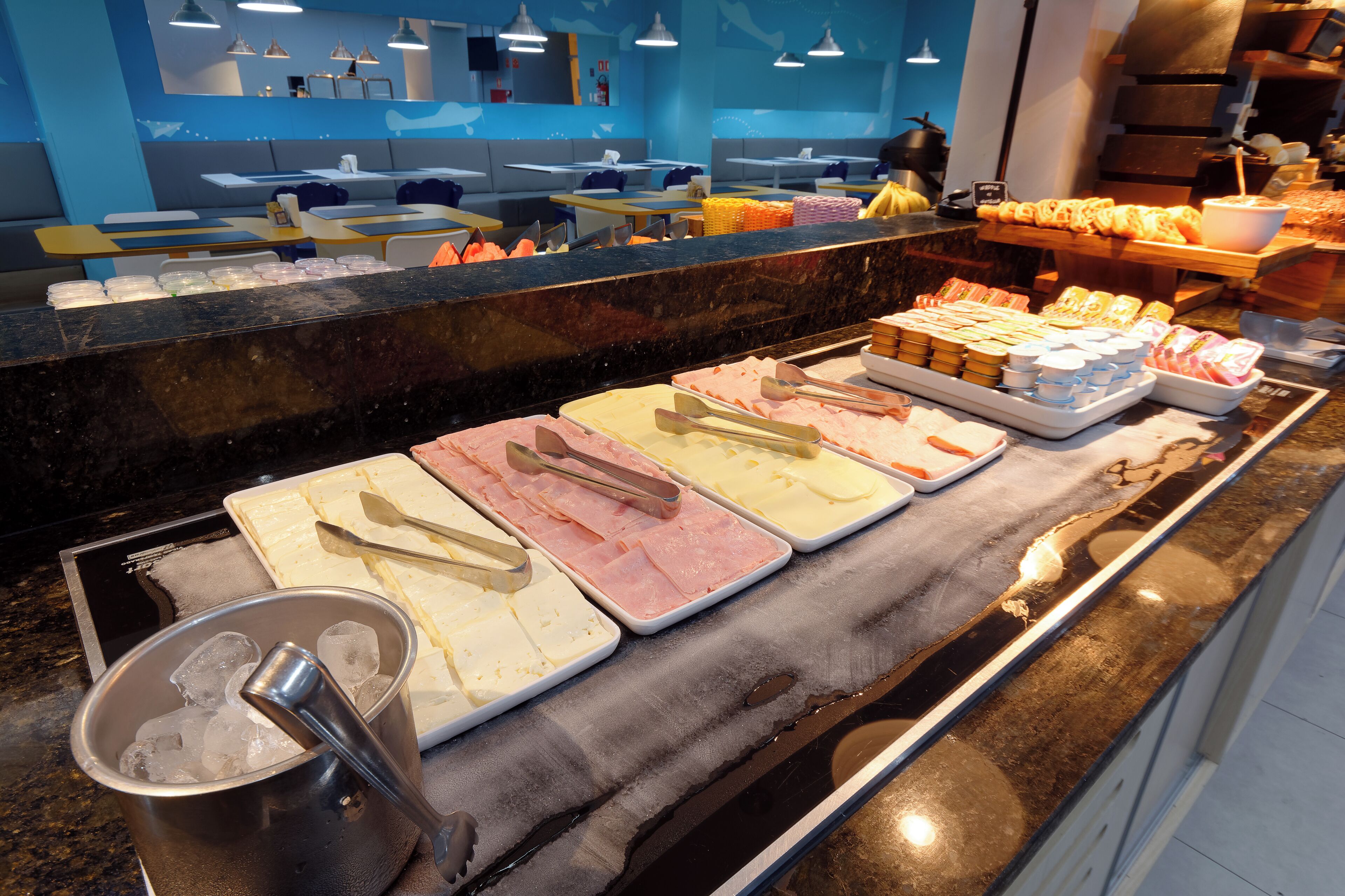 Monipuolinen buffet, jossa on tarjolla erilaisia ruokia ja ruokailuvälineitä.
