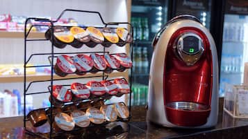 Uma máquina de café e uma seleção de cápsulas de café em um balcão.