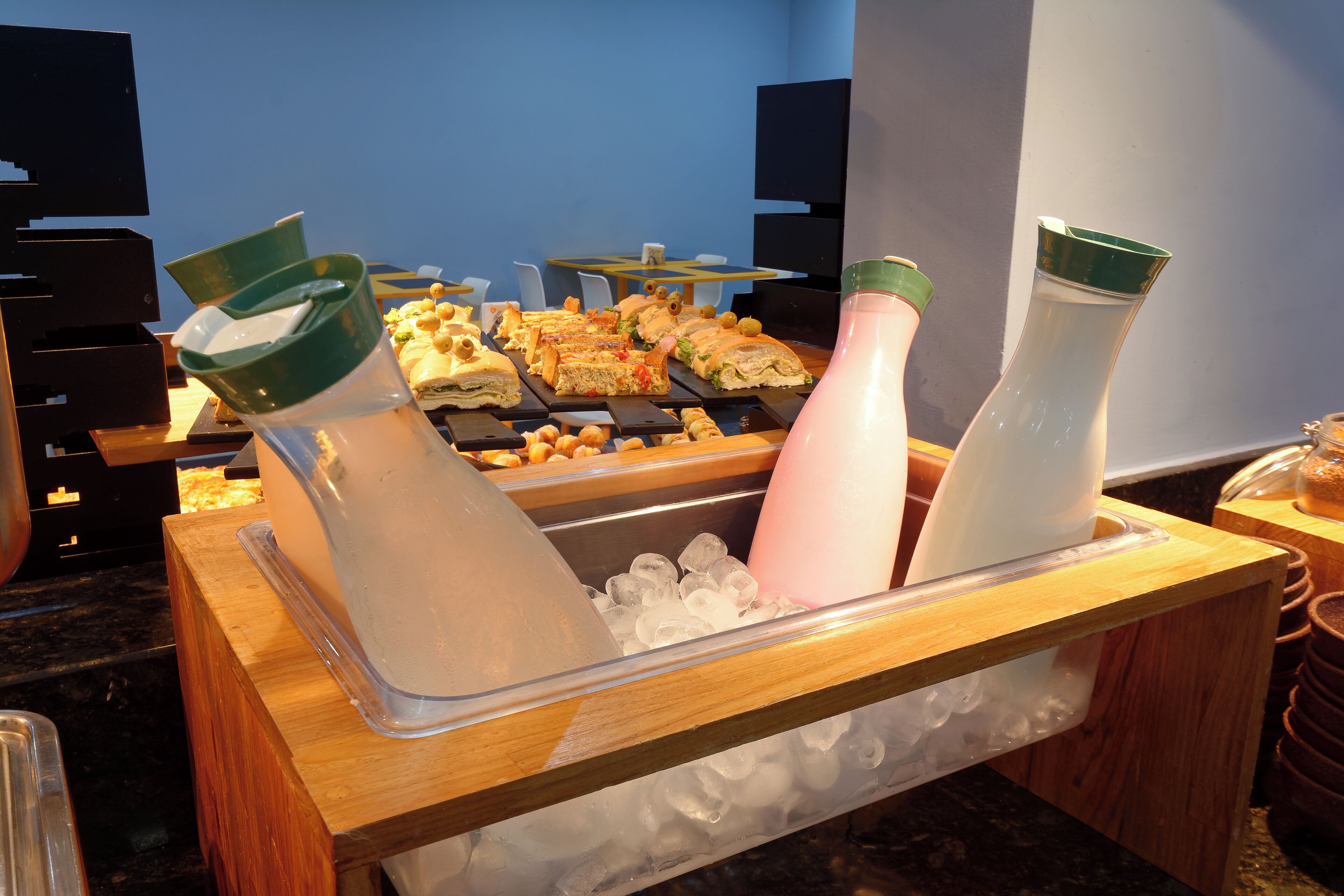 Een buffetopstelling met diverse gerechten en drankjes op een houten tafel.