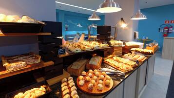 Buffet com diversos itens, incluindo doces, sanduíches e sobremesas.