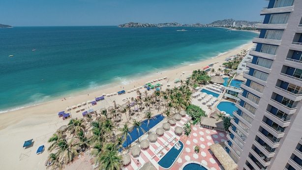 A resort with a beach, a pool, and a view of the sea. - Playa Suites Acapulco (Acapulco)