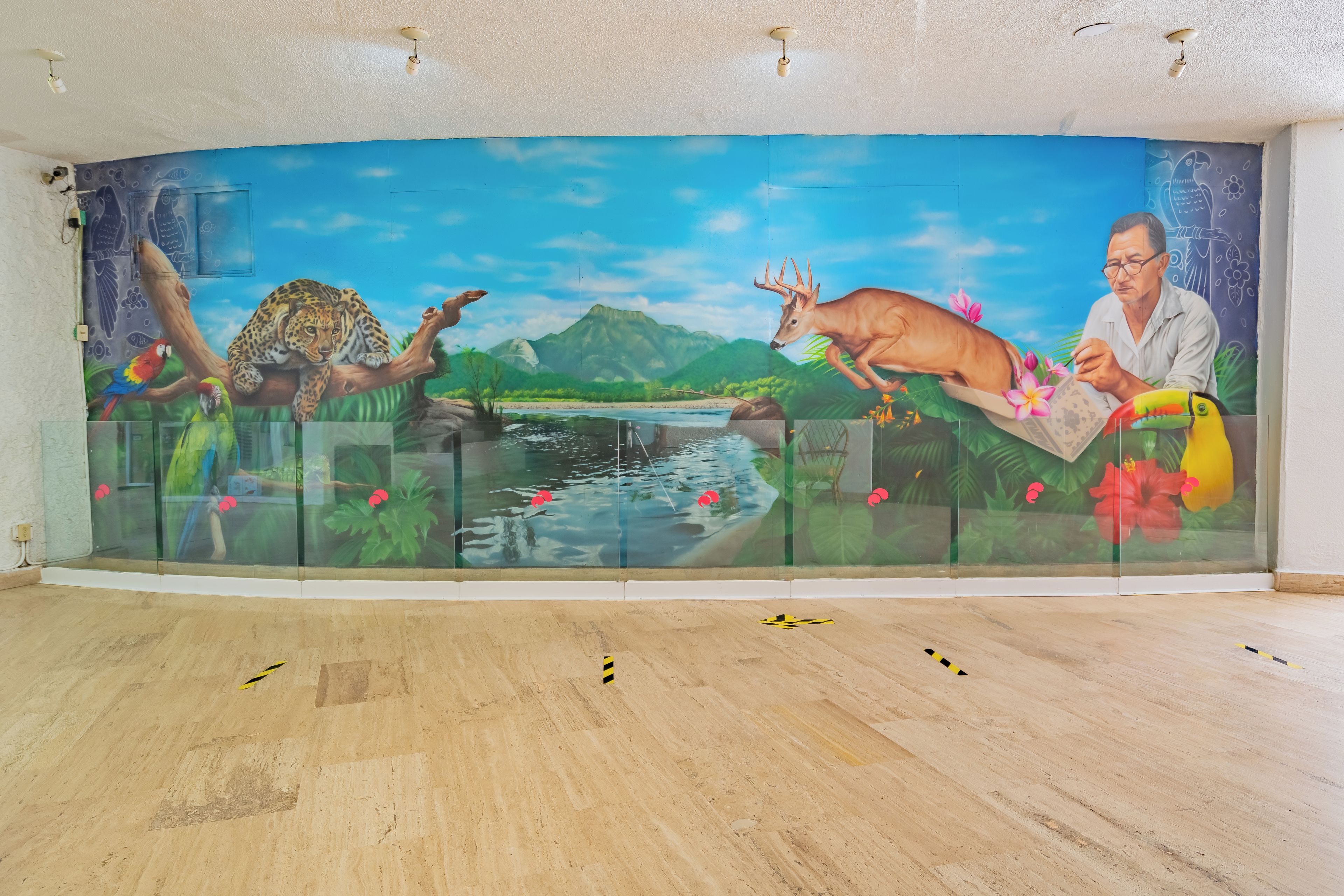 A mural with a leopard, deer, and parrot on a glass partition.