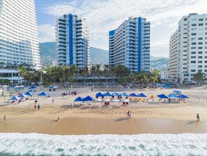 Plage, sable blanc, chaises longues, parasols