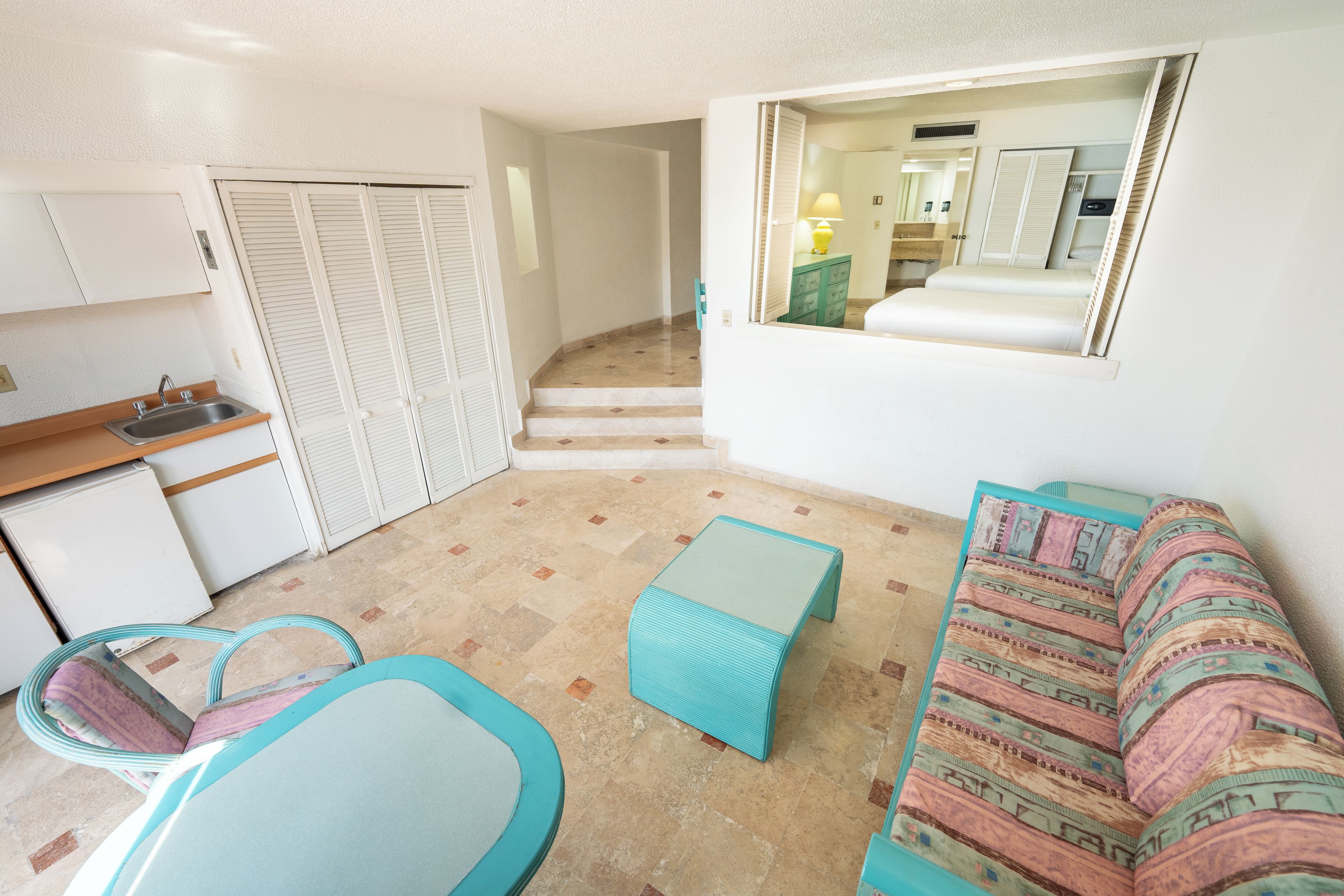 A compact living space with a kitchenette, a sofa, and a dining area.