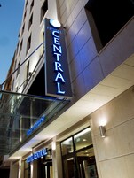 A hotel sign with the name "HOTEL CENTRAL" illuminated in blue.