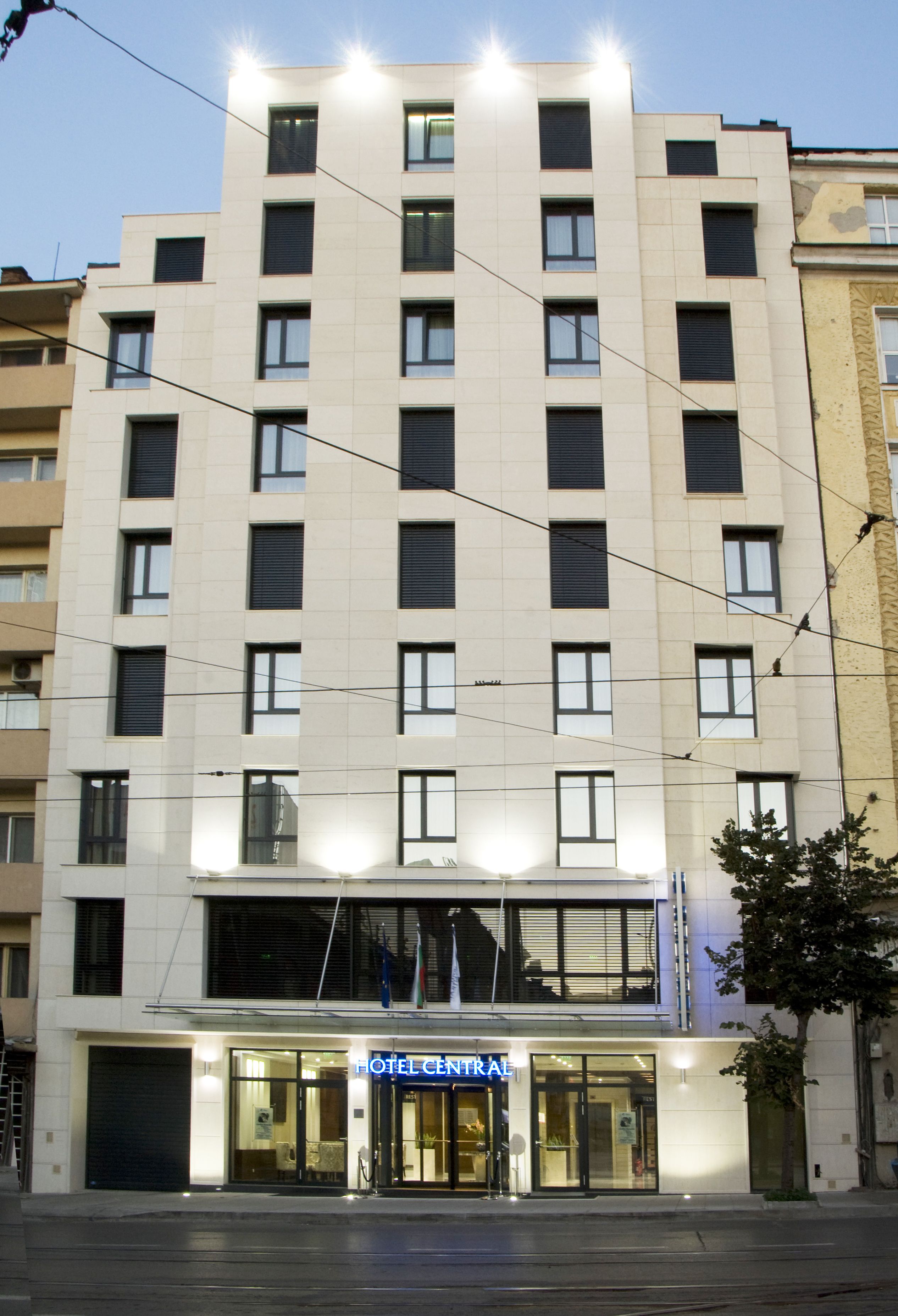 A multi-story hotel with a central entrance, large windows, and a flat facade.