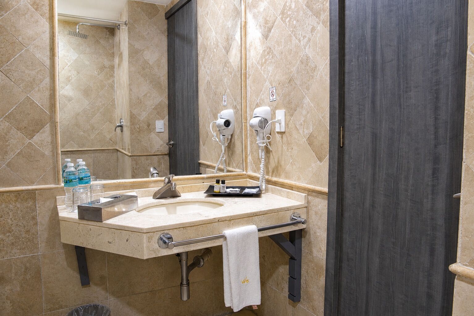 Un baño con lavabo, toallero y secador de pelo.